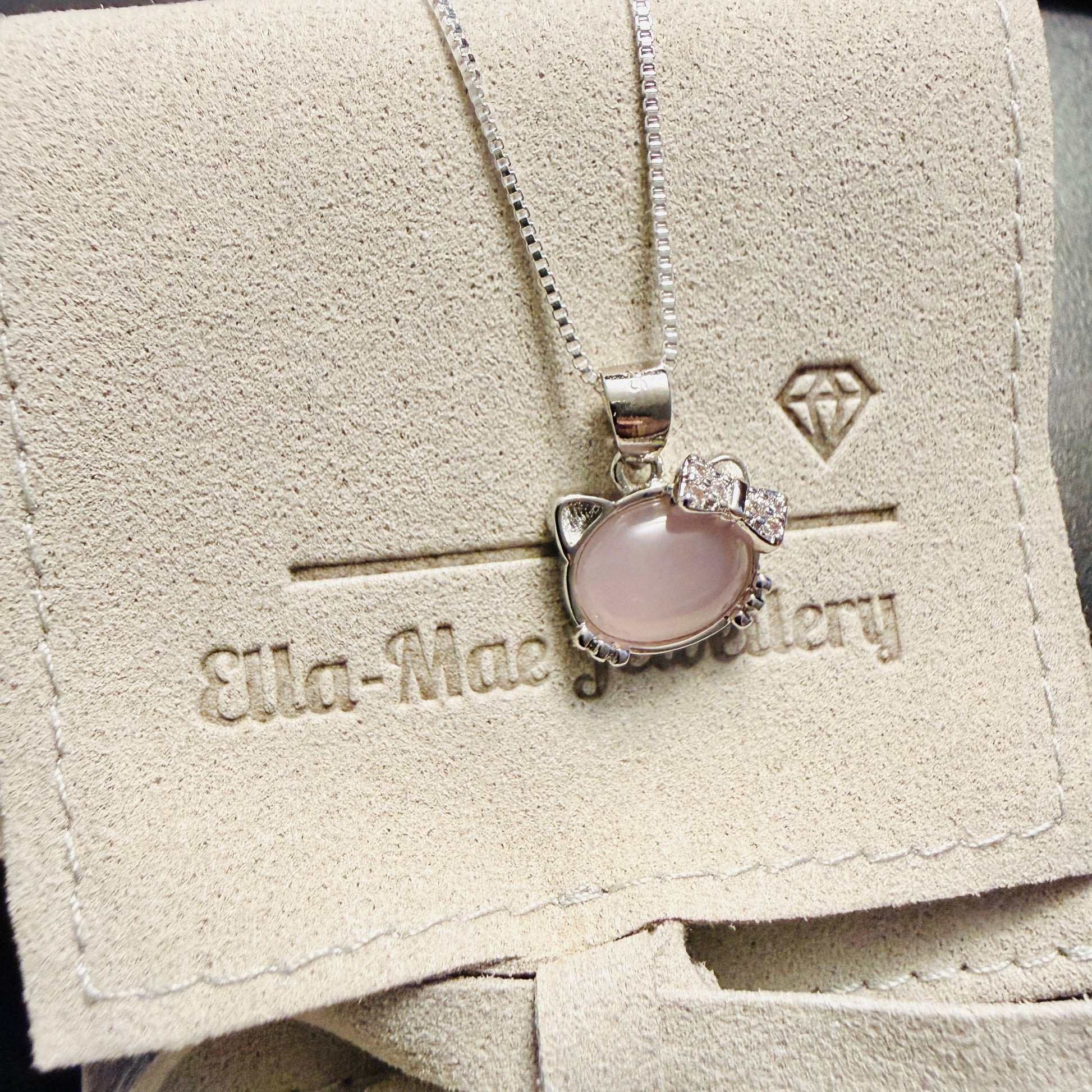 Cute Kitty pendant with pink opal on a silver chain, displayed on Ella Mae Jewellery branded gift pouch